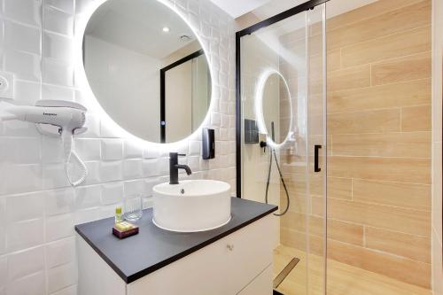 a bathroom with a sink and a mirror at Modern and functional apartment Ménilmontant in Paris