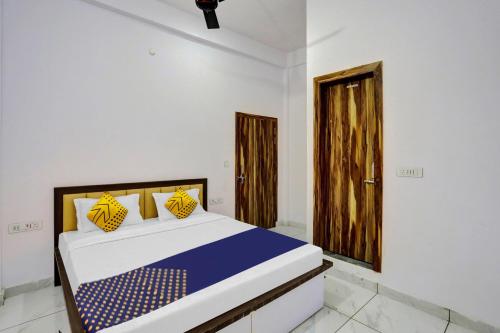 a bedroom with a bed and a wooden door at OYO Flagship Sardarji Hotel And Restaurant in Pushpagiri