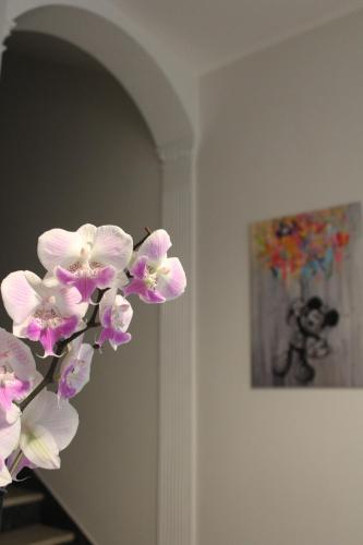 a bunch of pink flowers in a room with a painting at Casa Elvira in Nonantola