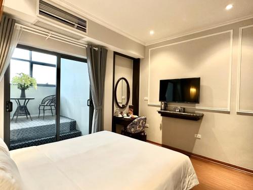 a bedroom with a bed and a flat screen tv at Salute Premium Hotel & Spa in Hanoi