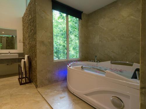 a large bathroom with a tub and a sink at Palmstone Retreat in Kitulgala