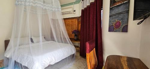 a bedroom with a bed with a mosquito net at Northern Pearl in Gulu