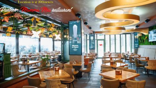 a restaurant with tables and chairs and windows at AMADA CITY CENTER in Iaşi