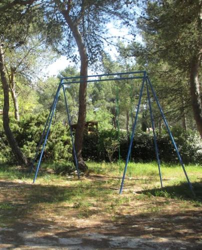 une balançoire dans un parc avec un arbre dans l'établissement appartement T3 dans propriété de 5000m2 avec piscine, à Venelles