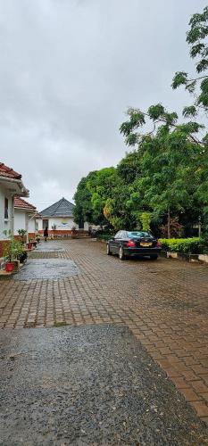 a car parked on a brick road next to a house at Northern Pearl in Gulu