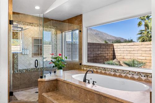 ein Bad mit einer Badewanne und einem großen Fenster in der Unterkunft Blue Waters at Andreas Hills in Palm Springs