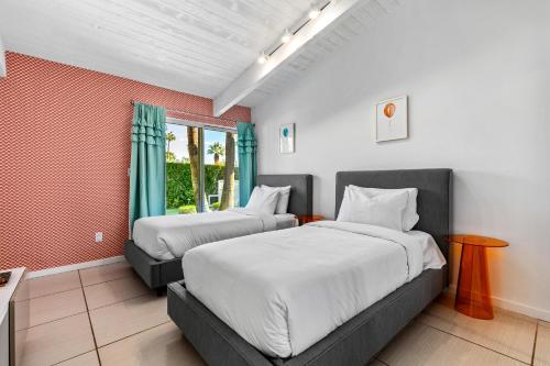 a bedroom with two beds and a window at Far Far Away in Vista Las Palmas in Palm Springs