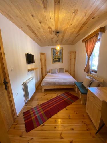 una camera con letto e soffitto in legno di Pubhouse & Rooms Pahulja a Kolašin