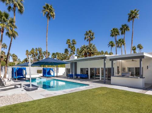 a house with a swimming pool and palm trees at Far Far Away in Vista Las Palmas in Palm Springs