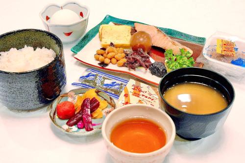 a table topped with bowls of food and bowls of soup at Hiroshima Ekimae Universal Hotel in Hiroshima