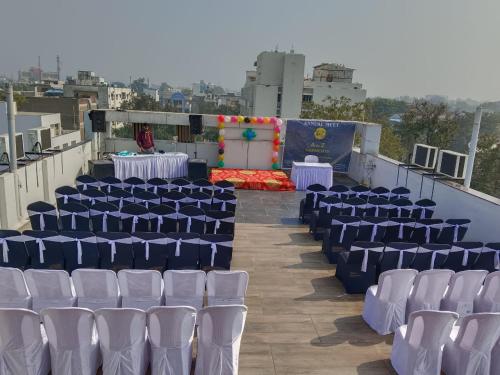 a banquet hall with blue and white chairs and a stage at HOTEL SIDDHALI INN in Jabalpur