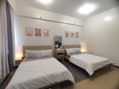 two beds in a room with white walls at Casa Mojica SMDC Hope Residences in Trece Martires