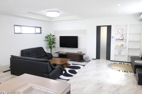 a living room with two chairs and a television at Condominium Felicita Naha in Naha