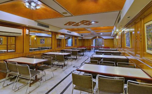 een eetkamer met tafels en stoelen bij OYO Hotel Kohinoor in Jaipur