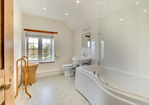 a bathroom with a tub and a toilet and a sink at Cross House in Saint Issey