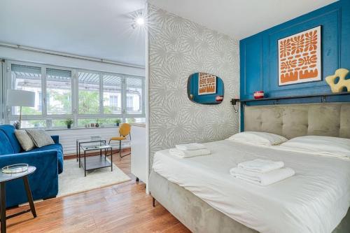 une chambre avec un lit et un mur bleu dans l'établissement Apartment 4Pers - Montparnasse/St Germain, à Paris