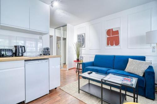 un salon avec un canapé bleu et une cuisine dans l'établissement Apartment 4Pers - Montparnasse/St Germain, à Paris