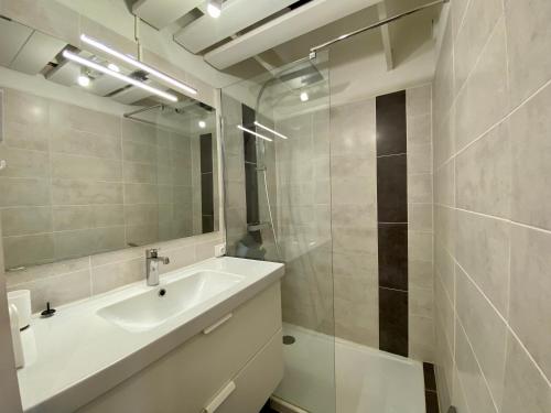 une salle de bain avec un lavabo et un miroir dans l'établissement Le nid douillet du Cabestan, au Grau-du-Roi