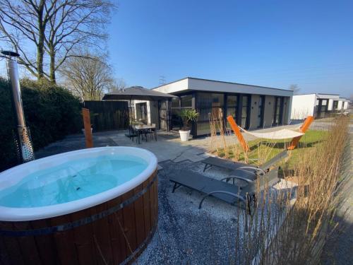 een hot tub in een tuin naast een huis bij Luxe 4- persoons Veluwelodge met hottub in Ermelo! in Ermelo