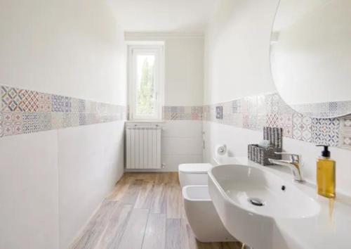 bagno bianco con lavandino e specchio di RESIDENCE MARATTA 54 a Terni