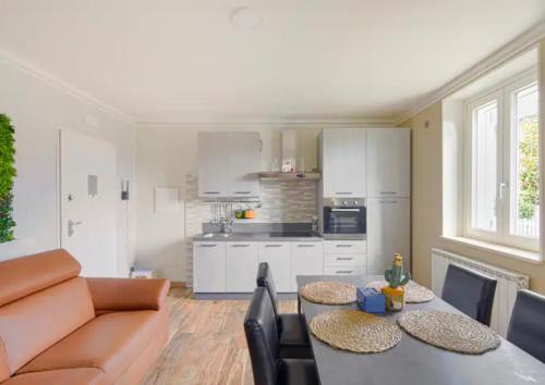 a kitchen and living room with two tables and a couch at RESIDENCE MARATTA 54 in Terni
