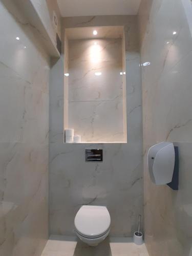 a bathroom with a toilet and a marble wall at Hotel PEKING in Sarajevo