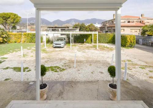 a car parked in a parking lot with two potted trees at RESIDENCE MARATTA 54 in Terni