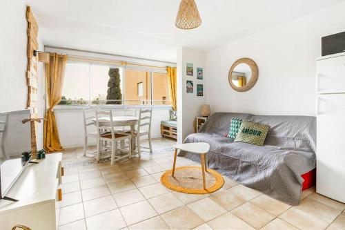 - un salon avec un lit et une table dans l'établissement Appart avec piscine, entre plage, port et falaises, au Cap d'Agde