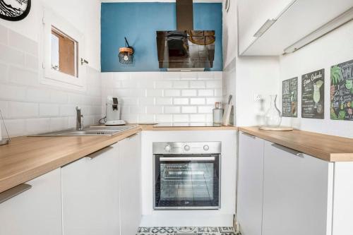 une cuisine avec des armoires blanches et un four dans l'établissement Appart avec piscine, entre plage, port et falaises, au Cap d'Agde