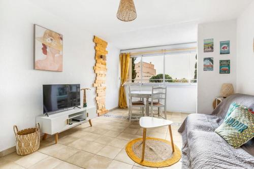 - un salon avec un canapé et une télévision dans l'établissement Appart avec piscine, entre plage, port et falaises, au Cap d'Agde