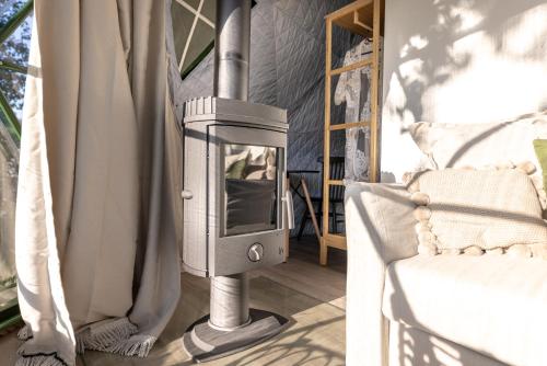 a wood stove in a room next to a chair at Glamping escape to the stars under Prague skyline in Prague
