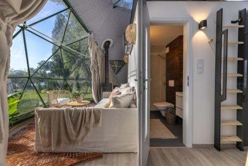 a room with a large window and a living room with a couch at Glamping escape to the stars under Prague skyline in Prague