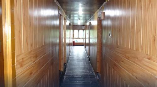 um longo corredor com paredes com painéis de madeira e um longo corredor em Hotel New Mount View Gulmarg em Gulmarg