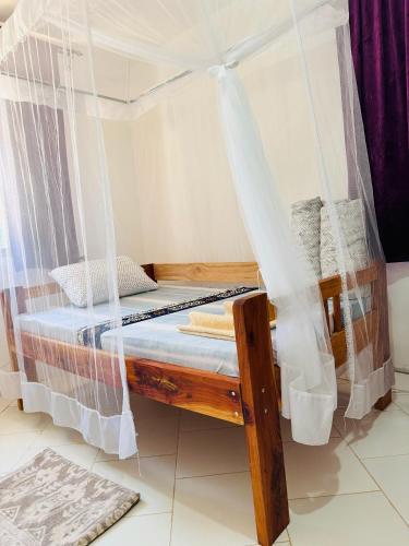 a bed with a mosquito net in a room at Karibu Africa Home in Moshi