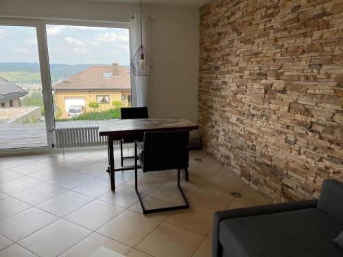 a dining room with a table and a brick wall at Ferienwohnung Lara in Bad Breisig