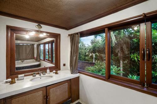 baño con lavabo y ventana grande en Villa Sujati en Ubud