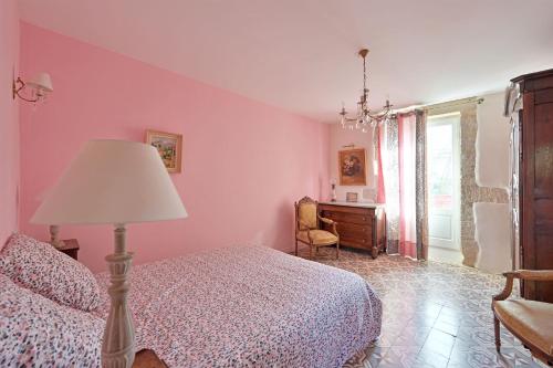 Schlafzimmer mit rosa Wänden, einem Bett und einem Schreibtisch in der Unterkunft Magnifique maison de famille - 3 mn à pied du centre in Uzès