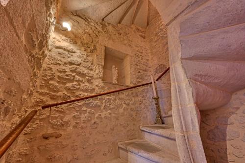 - un escalier dans un bâtiment en pierre avec un escalier dans l'établissement Magnifique maison de famille - 3 mn à pied du centre, à Uzès