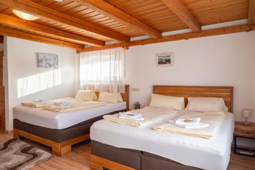 two beds in a room with wooden ceilings at Grüner Baum in Külsheim