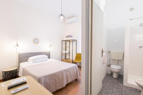 a white bedroom with a bed and a bathroom at Hotel Castello in Turin