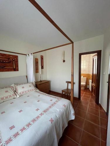 a bedroom with a large bed and a bathroom at Casa Padriñan in Sanxenxo