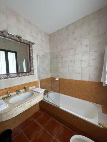 a bathroom with a tub and a sink and a mirror at Casa Padriñan in Sanxenxo