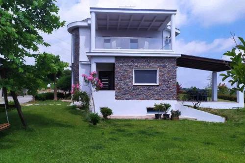 a house with a green lawn in front of it at Zeusplace Olympous Riviera Villa 1 in Litochoro