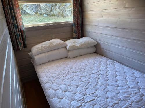 Cama pequeña en habitación con ventana en Kyrping Camping en Kyrping