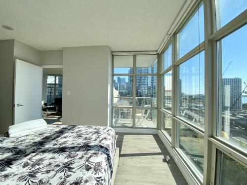 a bedroom with a bed and large windows at Luxury Homestay in Toronto