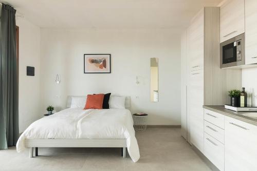 una camera bianca con letto e cucina di Agriturismo I sentieri del Vino - Lago Lucone a Polpenazze del Garda