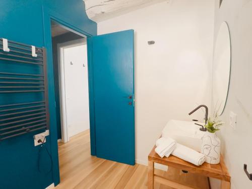 Habitación con puerta azul y mesa con toallas en Modern Loft Rho Fiera Milano, en Rho