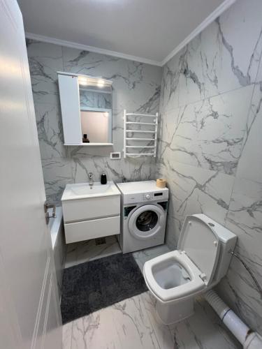 uma casa de banho branca com um WC e um lavatório em Sunny Accommodation Suceava 56 em Suceava