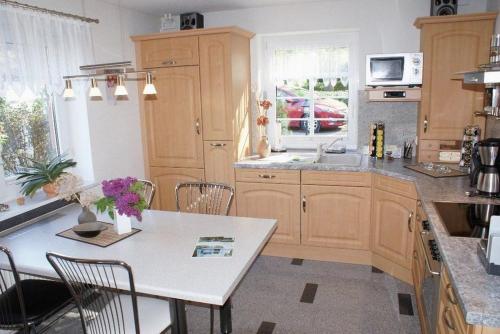 a kitchen with wooden cabinets and a table with chairs at Beckerhof - ABC54 in Dorf Mecklenburg