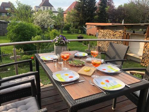 einen Holztisch mit Speise- und Weingläsern auf einer Terrasse in der Unterkunft Stadtvilla Brügemann - ABC136 in Wismar